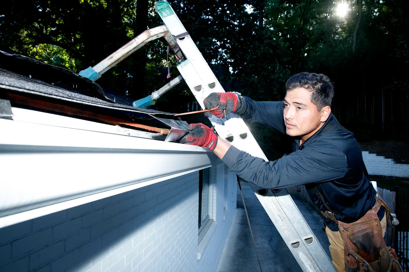 A Forsyth Exterminating technician working on the exterior of a home